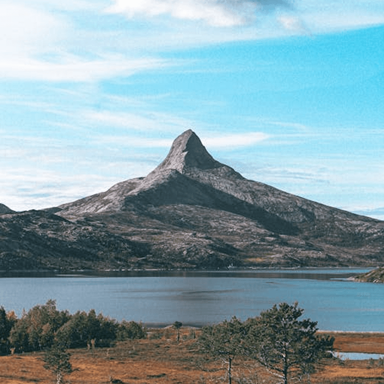 A steep peak rising above a still mountain lake